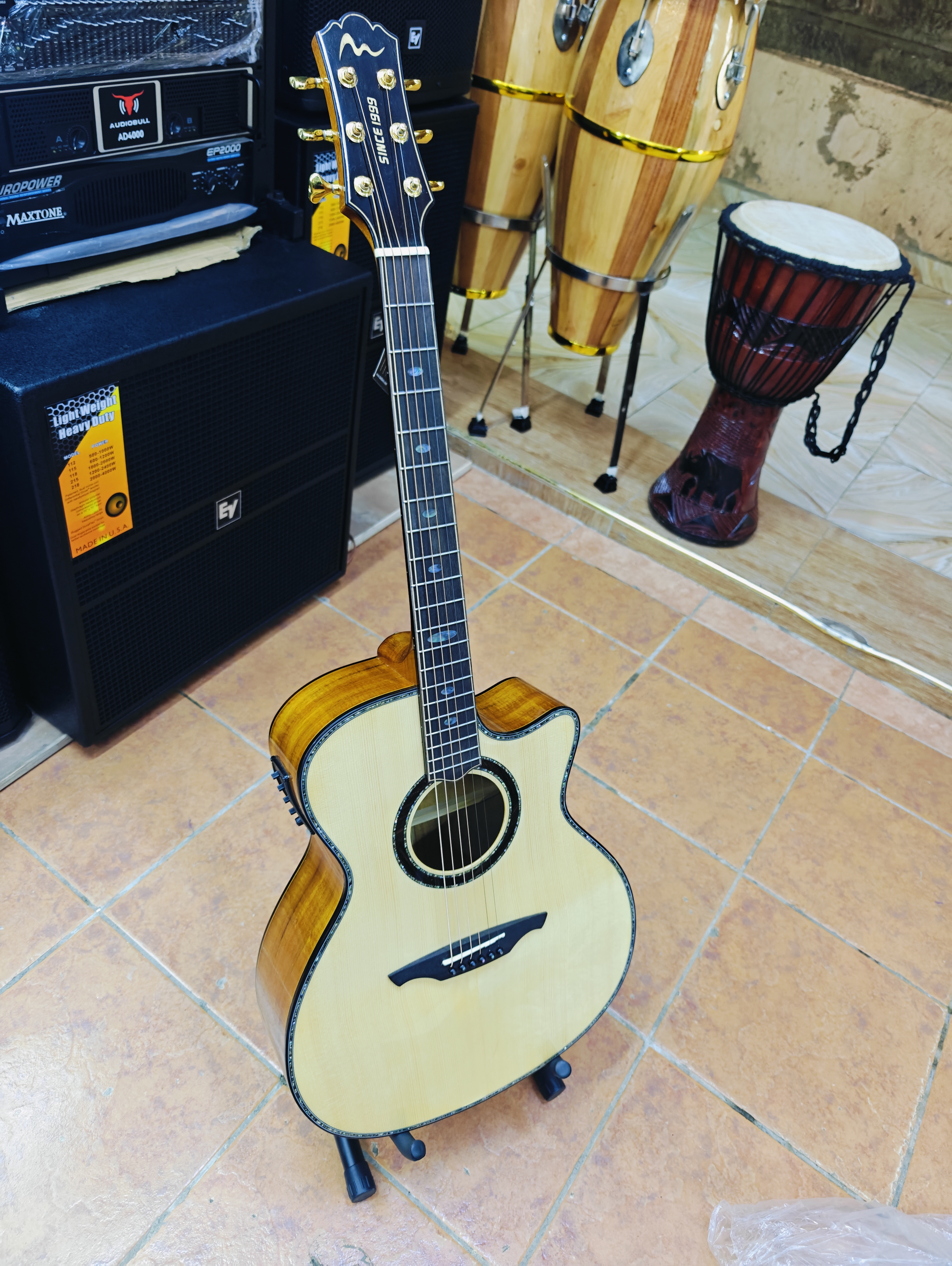 Spread Music solid spruce semi-acoustic guitar with cutaway body, natural finish, built-in pickup, and gold tuning mach