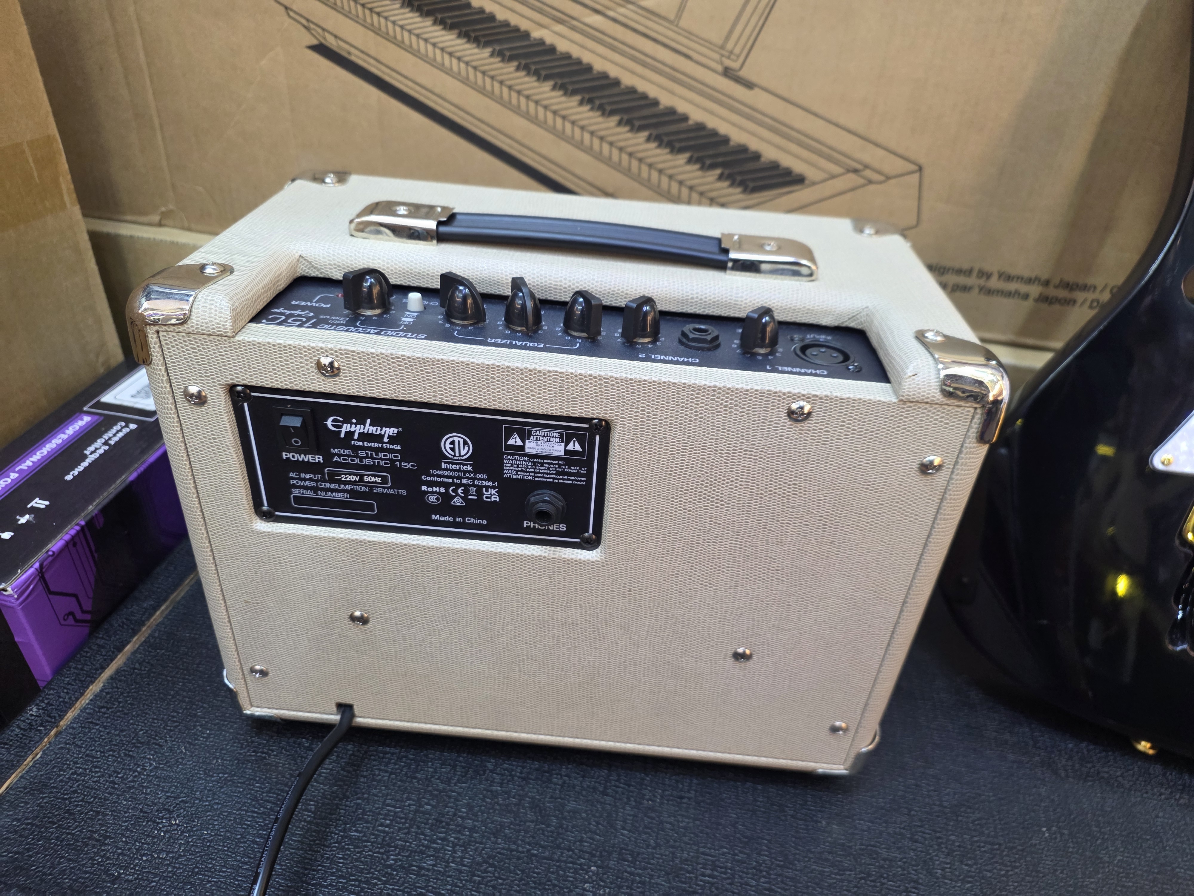 From the rear panel, this appears to be the Epiphone Studio Acoustic 15C amplifier (Model AC-15T1E-15C), designed for both acoustic and electric guitars. From the rear panel, this appears to be the Epiphone Studio Acoustic 15C amplifier (Model AC-15T1E-15C), designed for both acoustic and electric guitars.