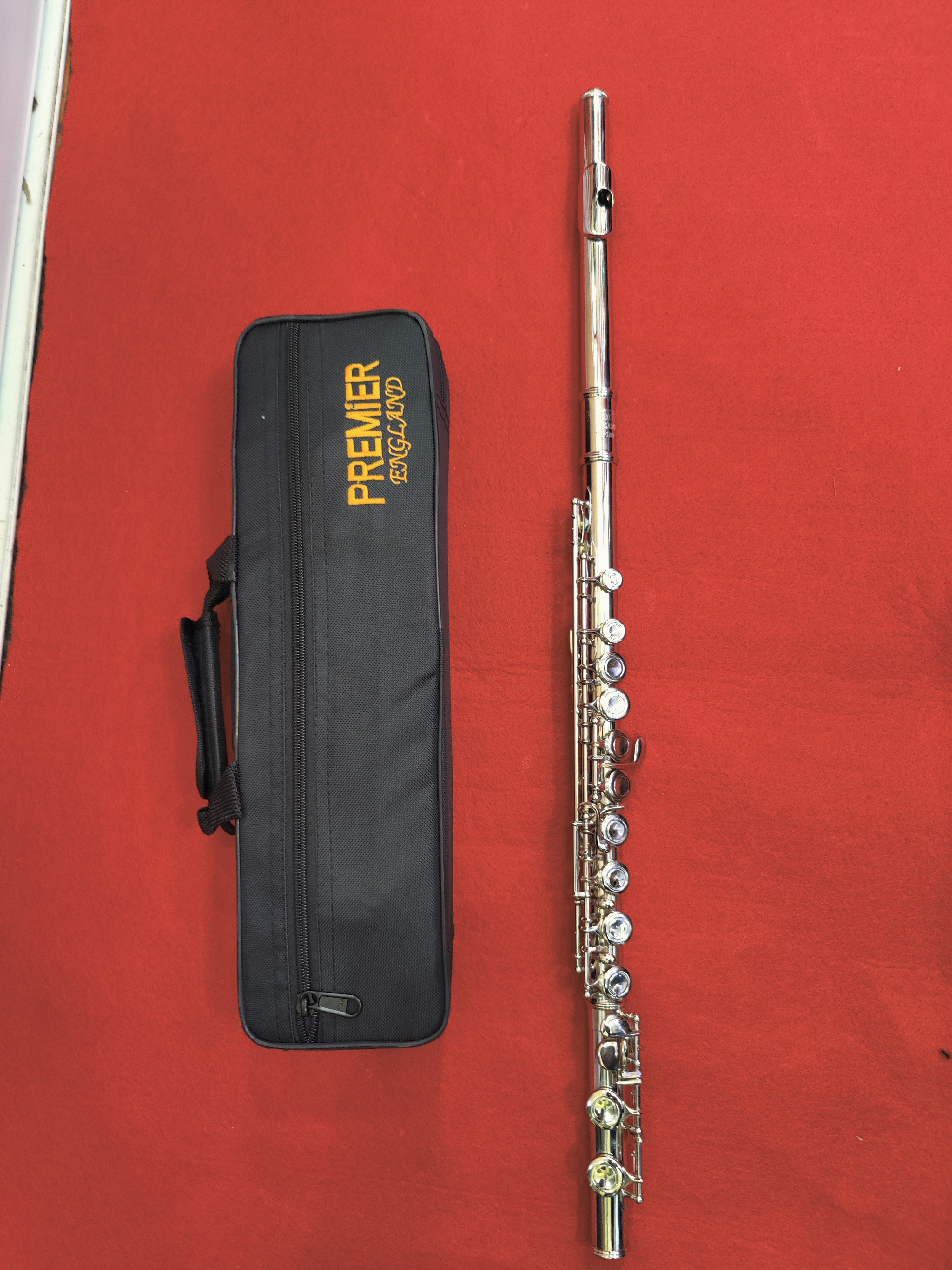 The Premier Silver Concert Flute is a beautifully crafted C concert flute designed for students, school bands, church musicians, and advancing performers. Featuring a sleek silver-plated finish, this flute produces a bright, clear, and well-balanced tone with excellent projection. Its precision-engineered key mechanism ensures smooth, responsive action and accurate intonation, making it comfortable to play for both beginners and experienced musicians. Lightweight, durable, and elegant, the Premier Silver Concert Flute is an excellent choice for practice, performances, and examinations. Key Features: Key of C Silver-plated finish Smooth and responsive key mechanism Bright, clear, and rich tone Excellent intonation and projection Lightweight and ergonomic design Ideal for students, schools, churches, orchestras, and concert bands Includes protective hard case, cleaning rod, polishing cloth, and carrying case